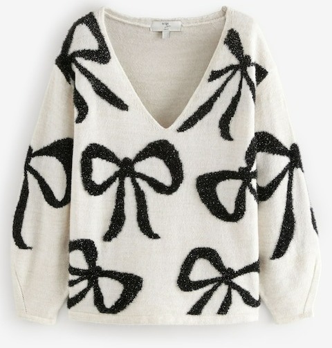 a white sweater with black bows on it