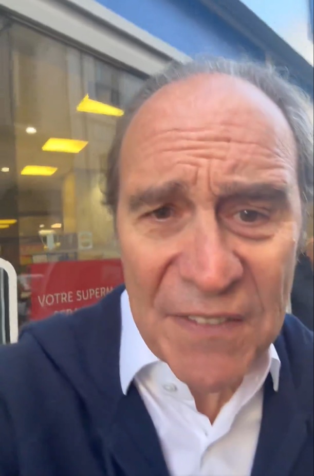 a man standing in front of a sign that says votre super