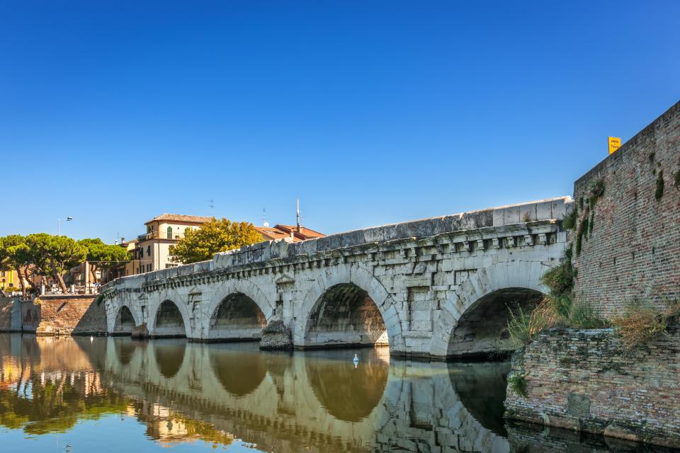 a bridge over a body of water with buildings in the background