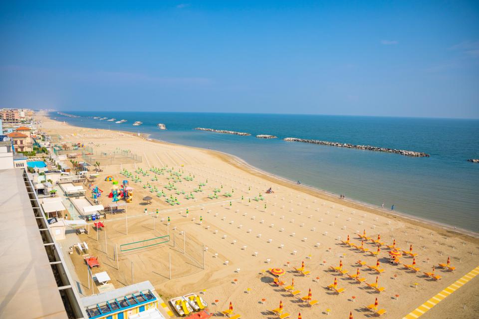 a beach with a lot of umbrellas and chairs