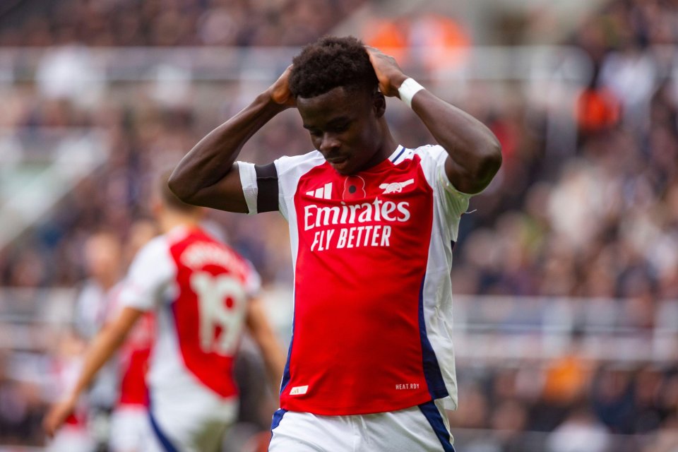 a soccer player wearing a red emirates fly better jersey