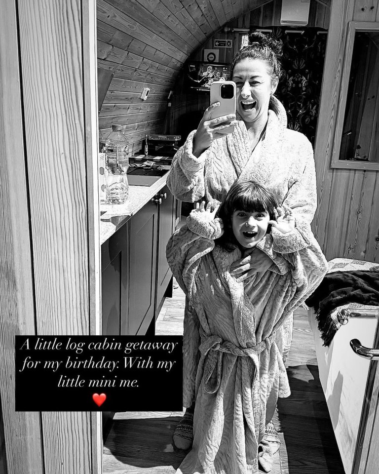 Woman and child in bathrobes in a log cabin.