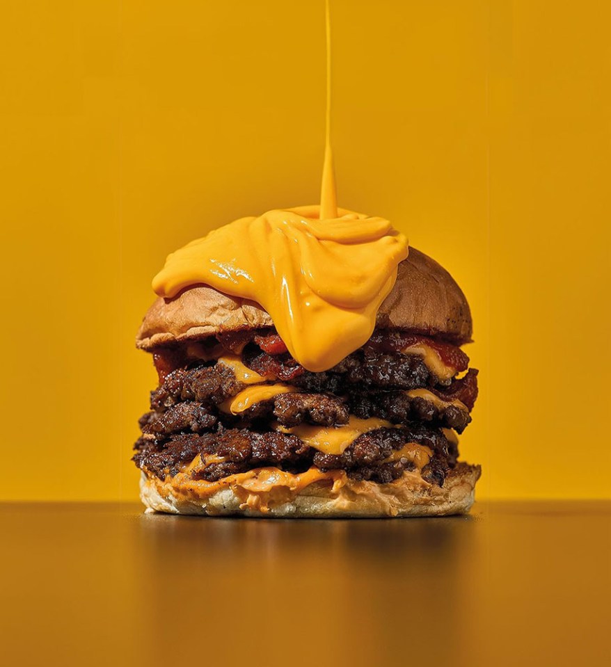 Triple-decker cheeseburger with melted cheese.