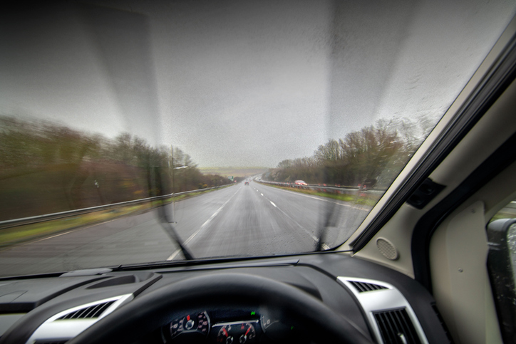 Rainy road seen from inside a car.
