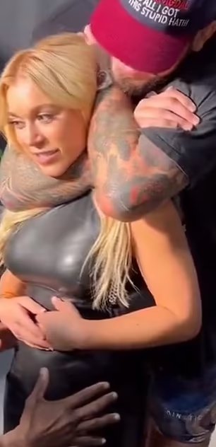 A man in a red hat uses a chokehold on a blonde woman.