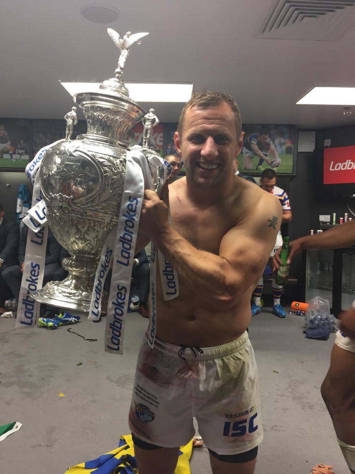 Rob Burrow holding a rugby trophy.