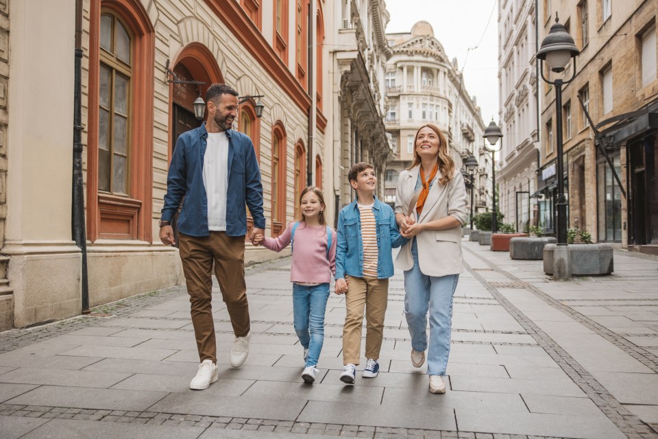 Happy family walking down a city street.