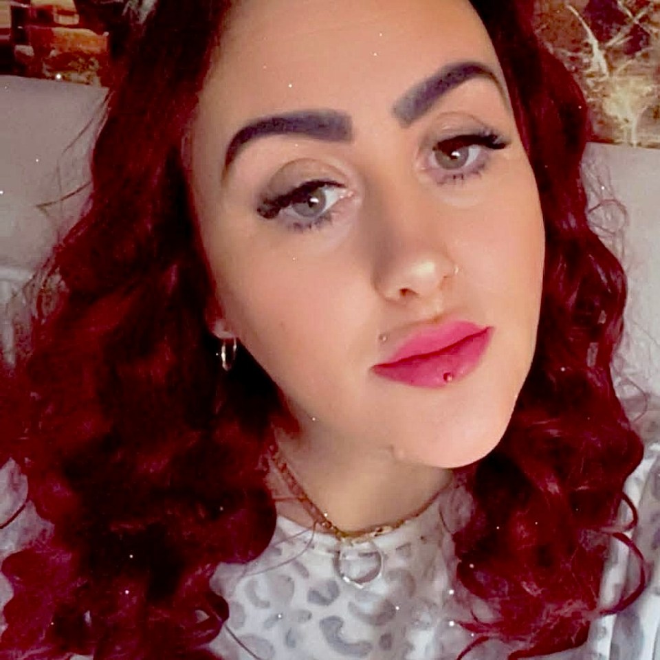 Portrait of a young woman with long, curly red hair.