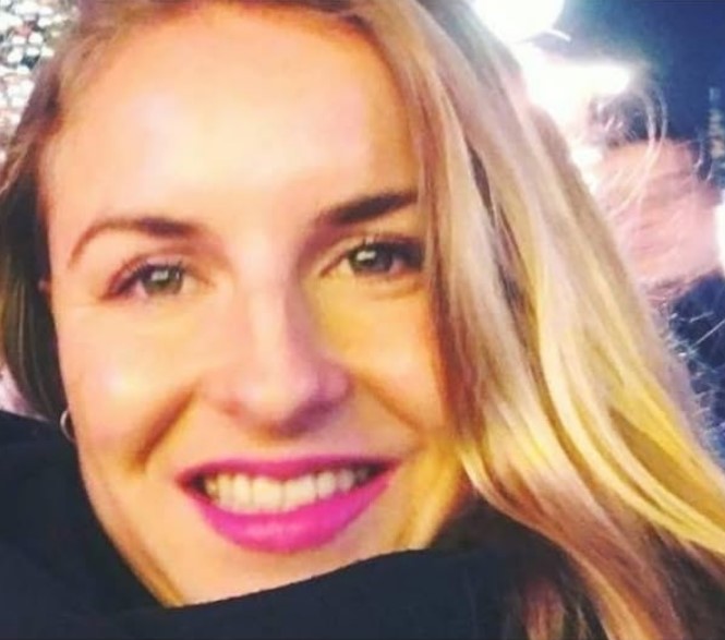 Close-up portrait of a woman with blonde hair and pink lipstick.
