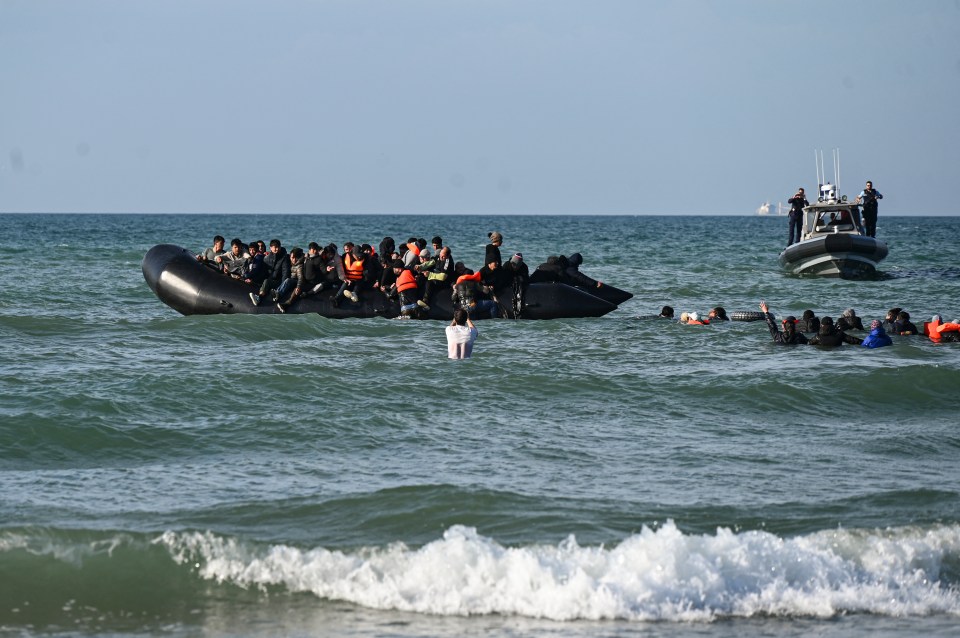 Migrants swimming toward a smuggler's boat in the English Channel.