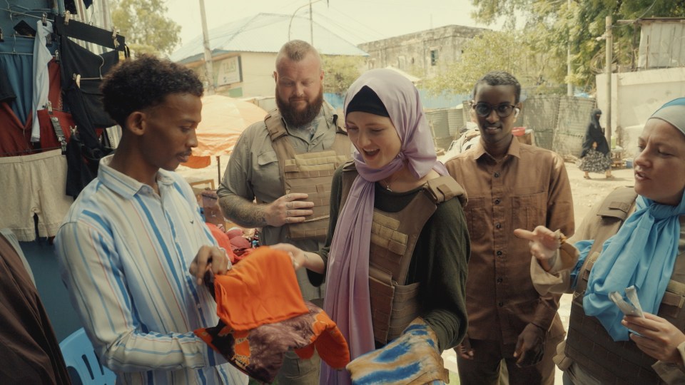 Three women and two men shopping at a market in Mogadishu, Somalia.
