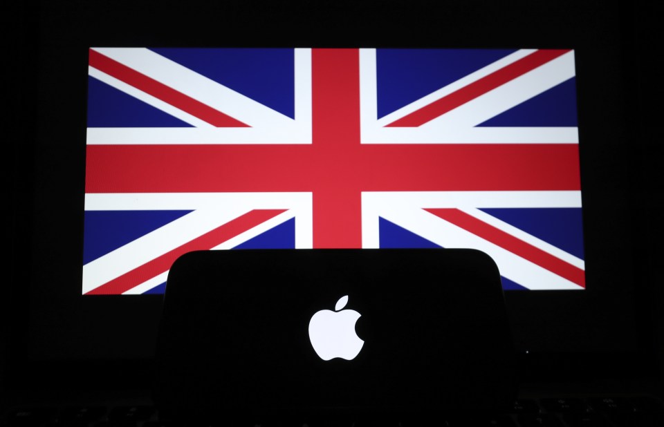 Apple logo on a smartphone silhouetted against the UK flag.