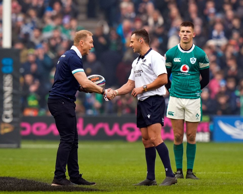 Sir Chris Hoy handing the match ball to the referee before a Scotland vs. Ireland rugby match.
