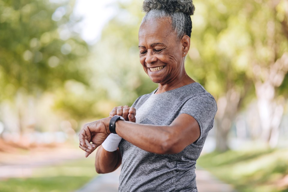 Senior woman checking her smartwatch outdoors.