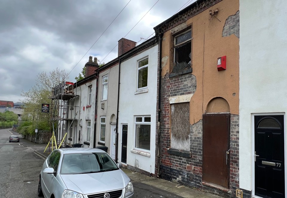A row of terraced houses, one of which has fire damage.