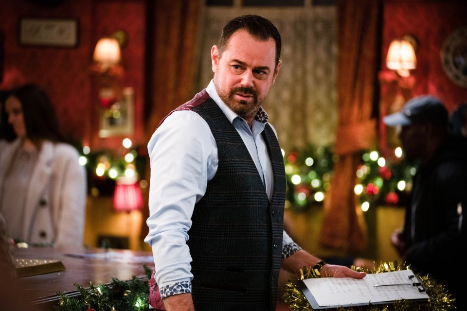 Mick Carter from EastEnders holding sheet music.