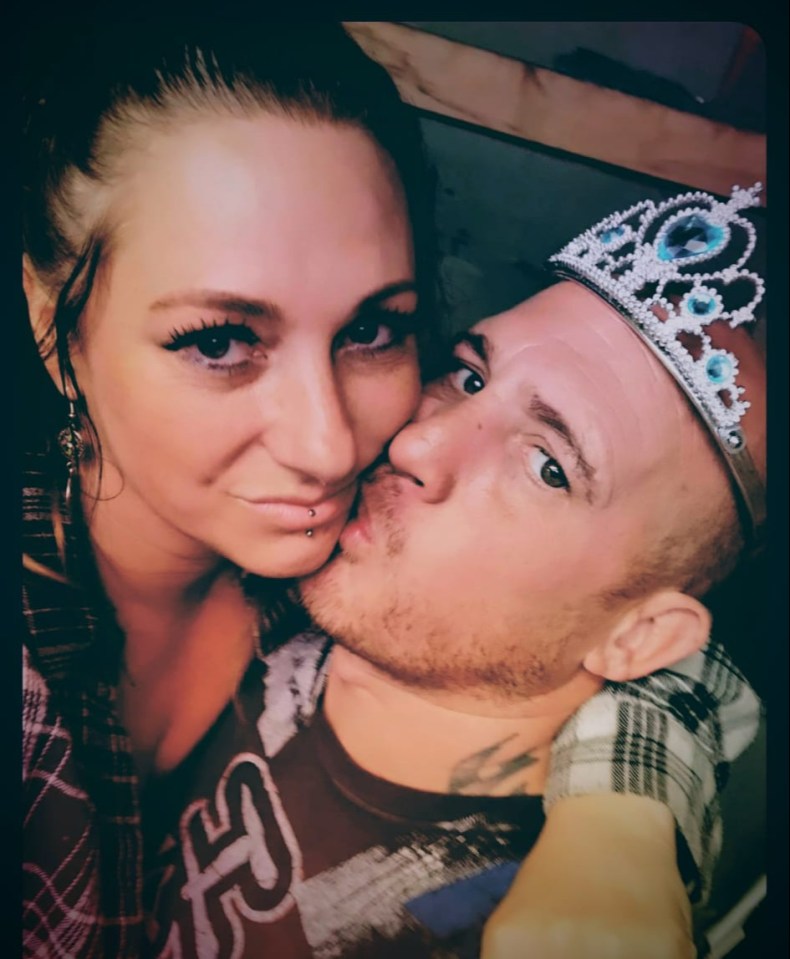 Close-up photo of a couple kissing; the man is wearing a tiara.