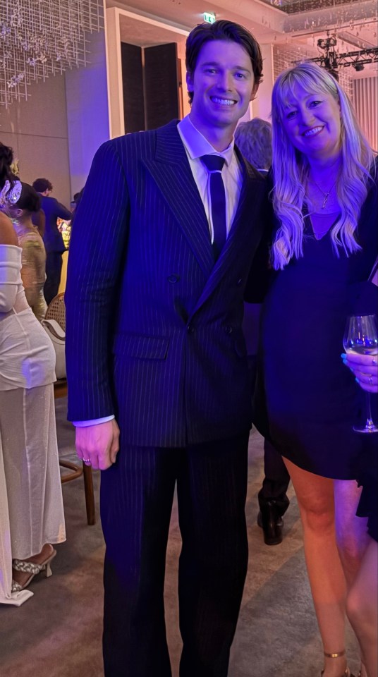 Man in pinstripe suit and woman in black dress at an event.