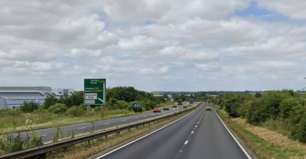 A multi-lane highway with cars driving on it.
