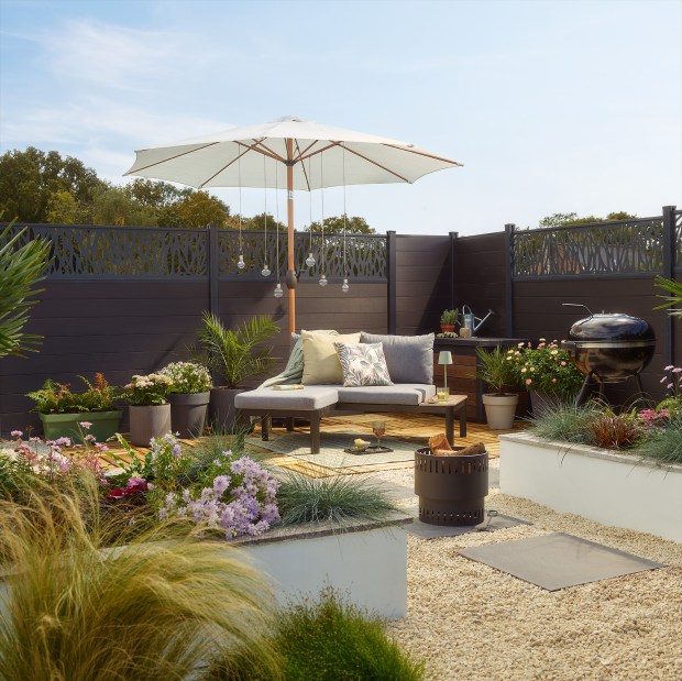 Modern patio with seating area, grill, and garden.