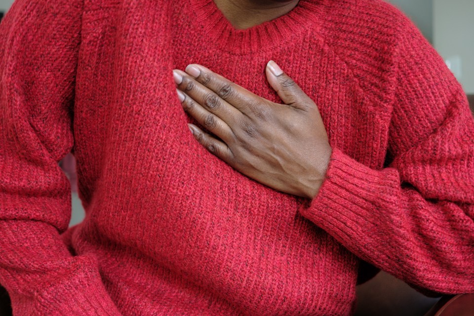 Close-up of a person holding their chest.