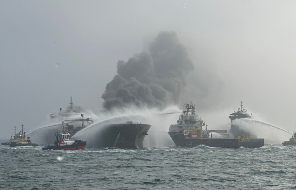Fire and rescue vessels battling a large fire on an oil tanker at sea.