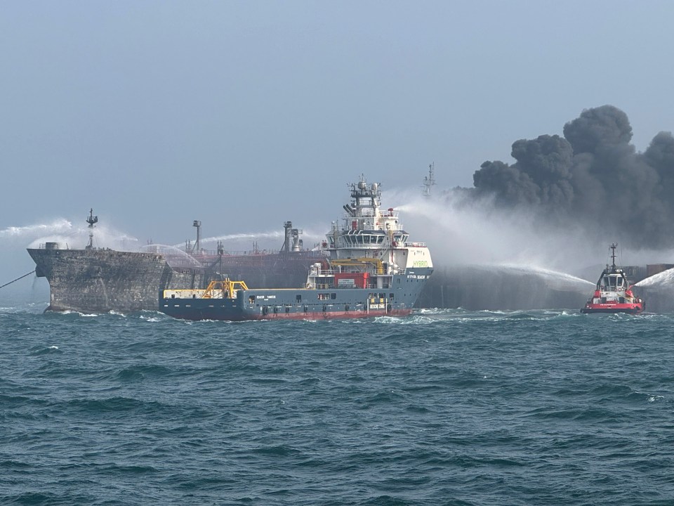 Fire and rescue vessels battling a fire on an oil tanker at sea.