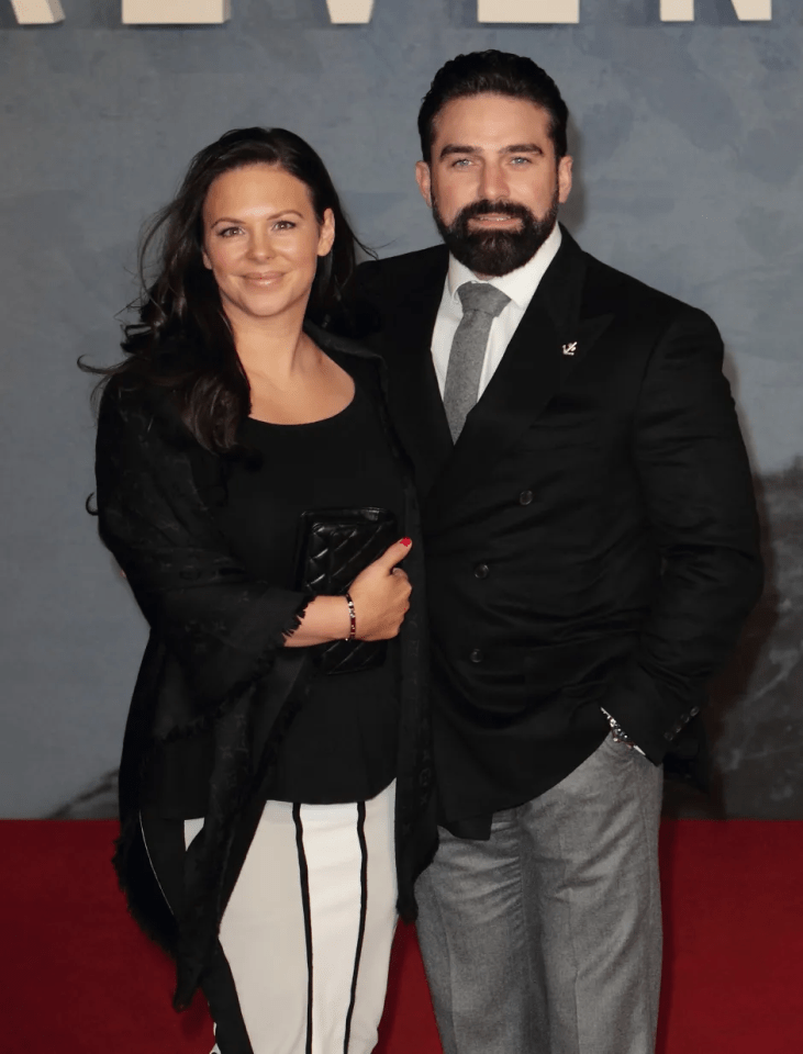 Couple posing for a photo on a red carpet.