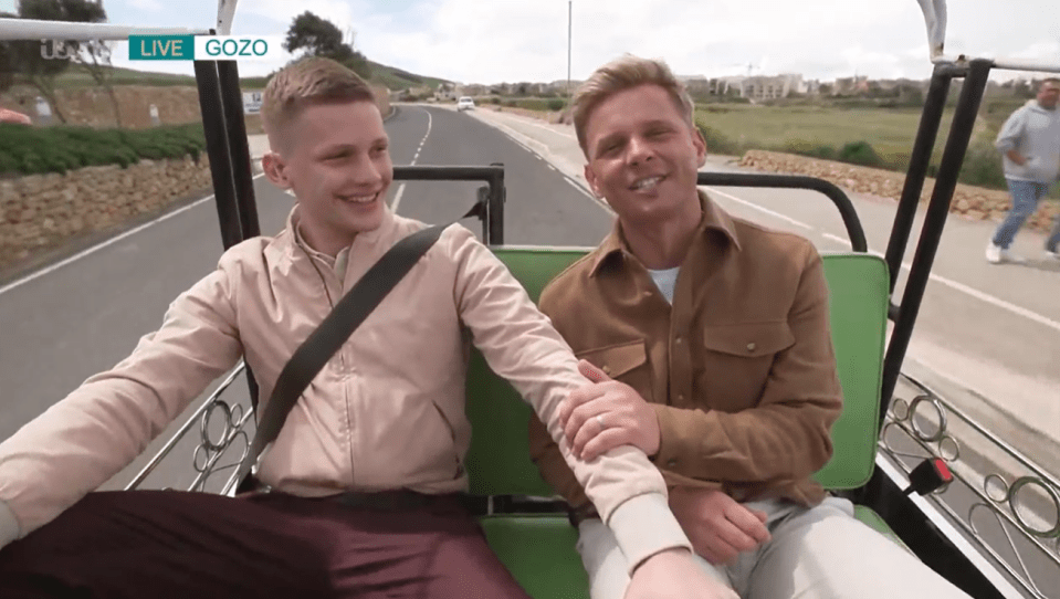 Two men riding in a small motorized cart.
