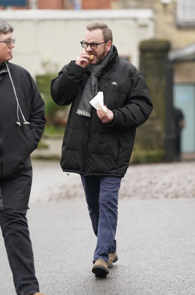 Kiefer Sutherland eating a pasty on the set of a film.