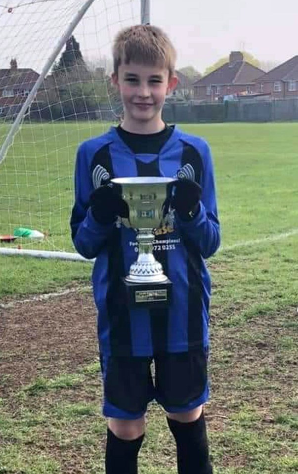 Photo of Max Dixon holding a soccer trophy.