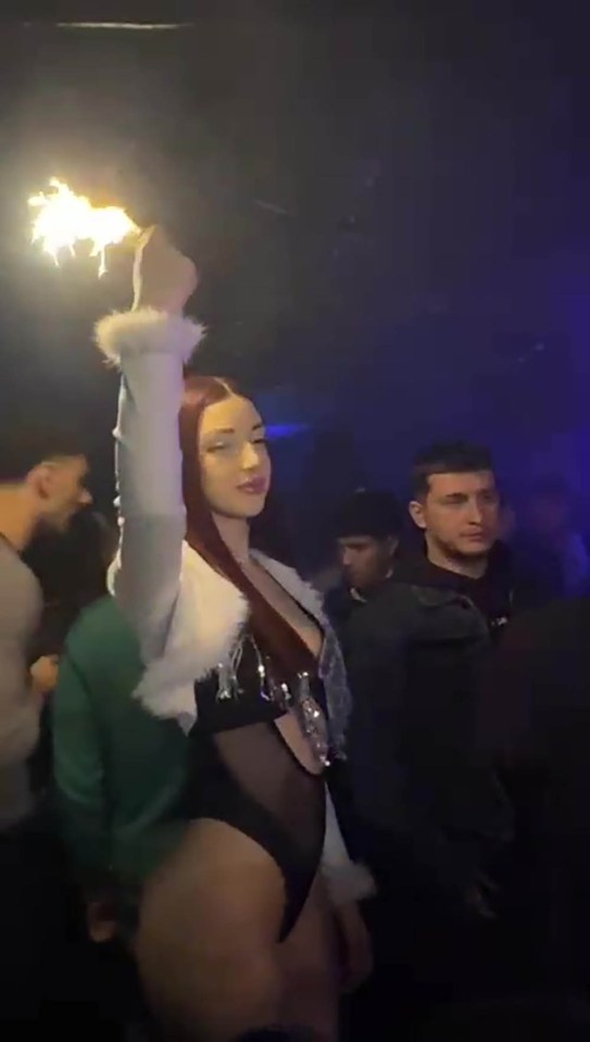 Woman holding a sparkler in a nightclub.