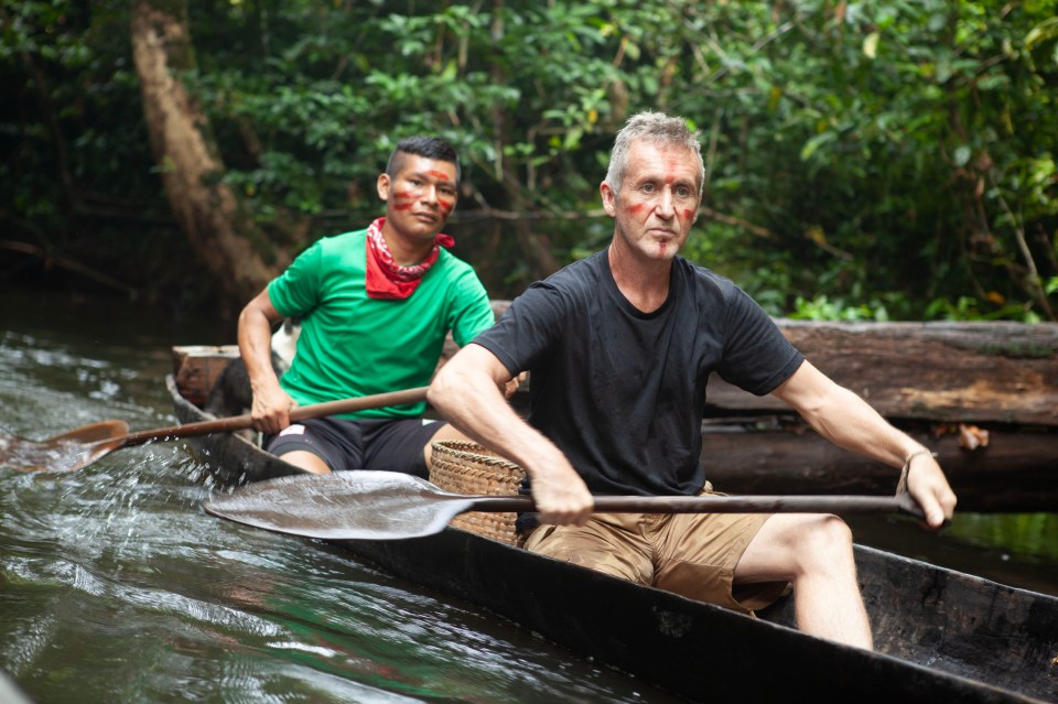 Two men canoeing on a river.