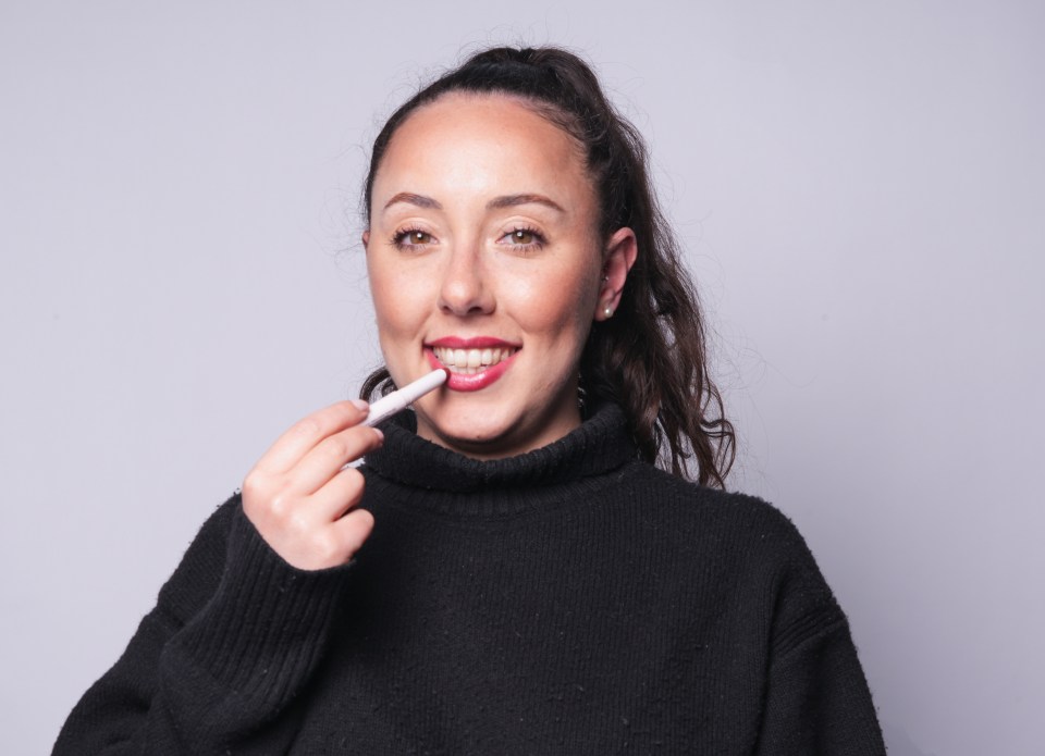 Woman applying lipstick.