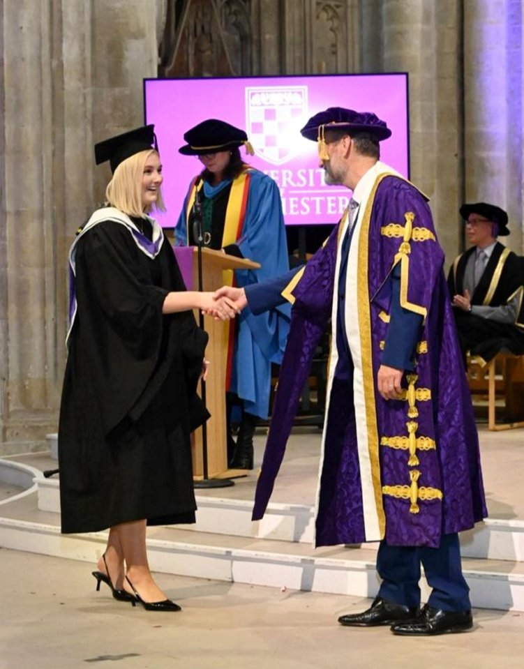 A graduate shakes hands with a university official at a graduation ceremony.