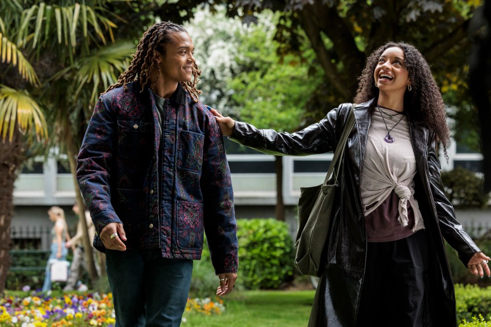 Two people walking and talking in a park.