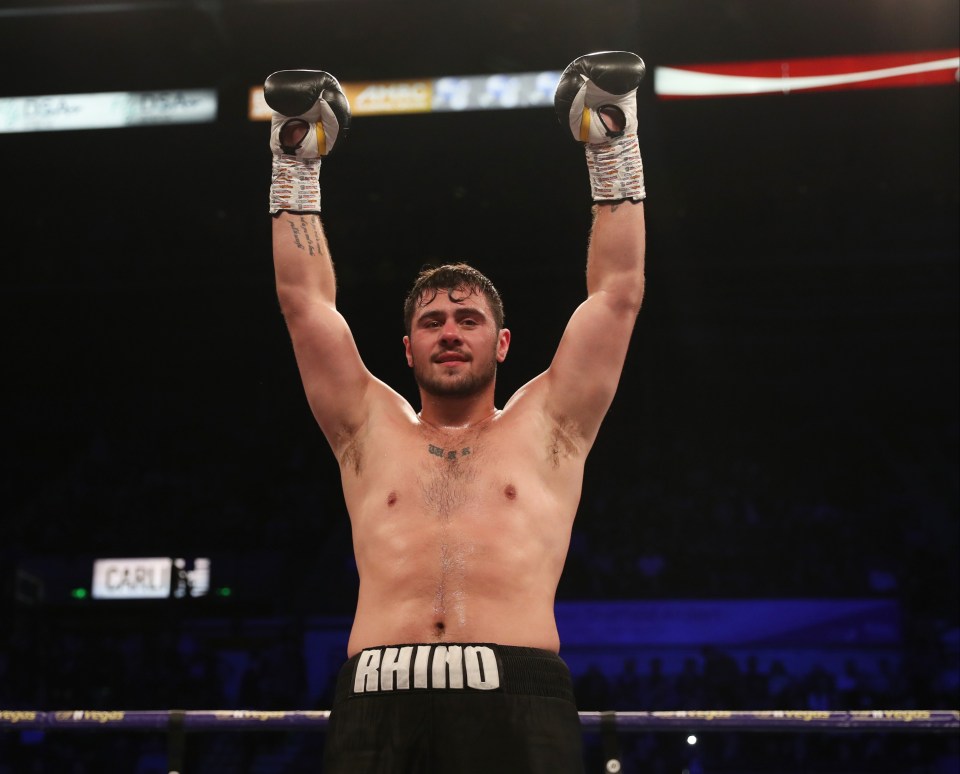 Boxer Dave Allen with arms raised in victory.