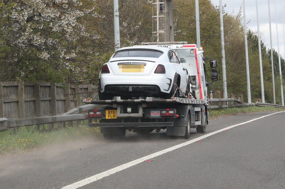 White Rolls Royce on a tow truck.