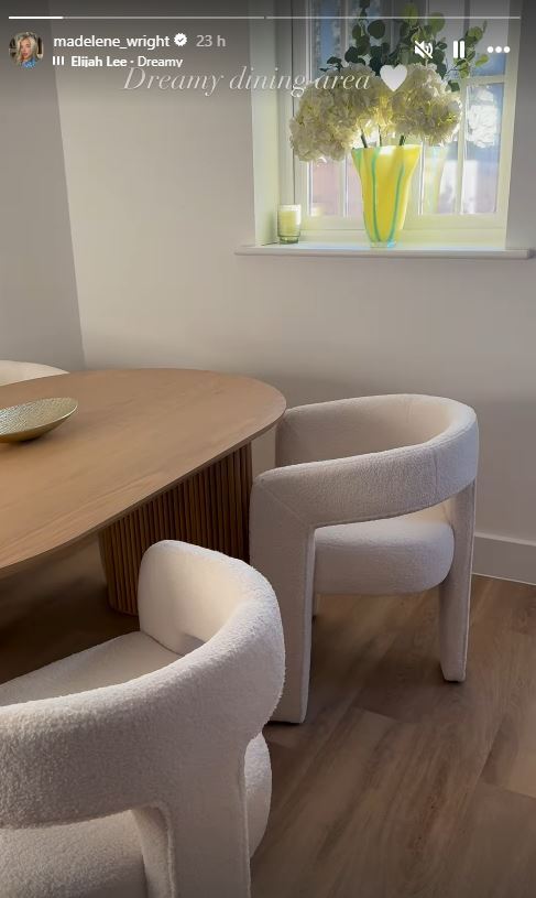 Dreamy dining area with a wooden table and fluffy white chairs.