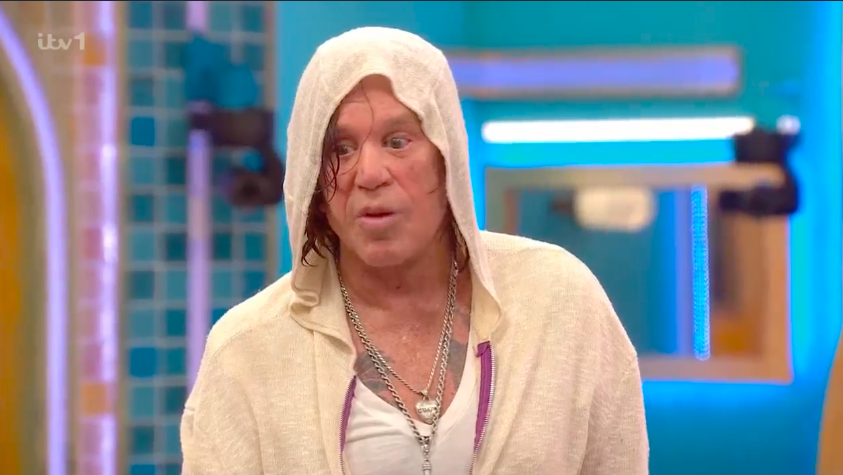Screenshot of a man in a white hooded sweatshirt.
