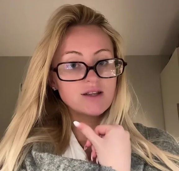 Woman in glasses explaining a situation.
