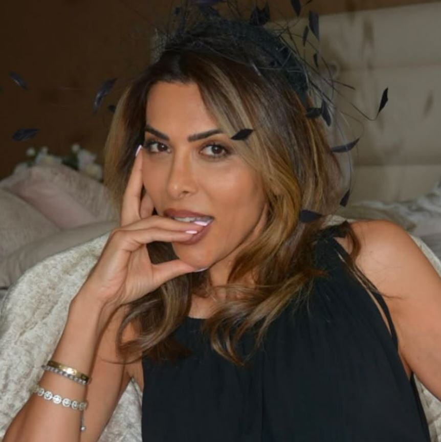 Portrait of a woman wearing a black headband and black dress.