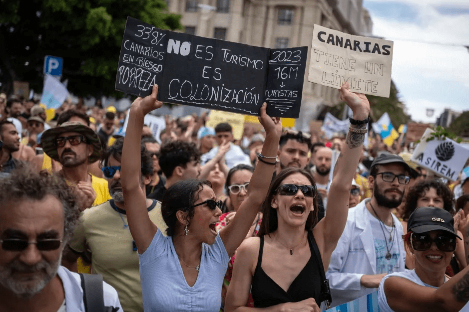 Protestors holding signs about overtourism in the Canary Islands.