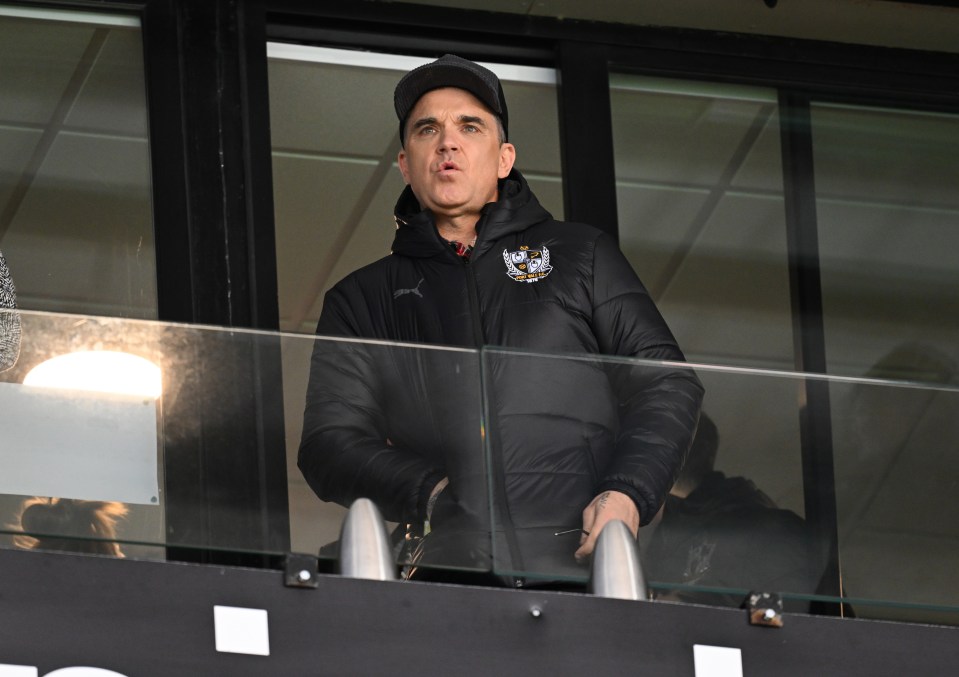 Robbie Williams, Port Vale president, watching a soccer match.