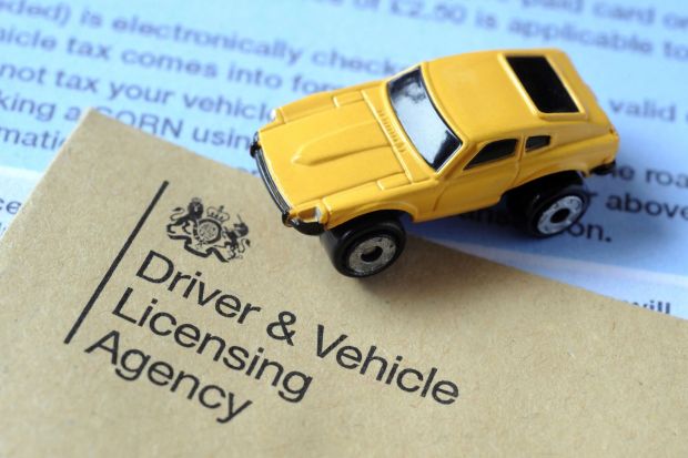 An image collage containing 1 images, Image 1 shows a yellow toy car sits on top of a driver and vehicle licensing agency form