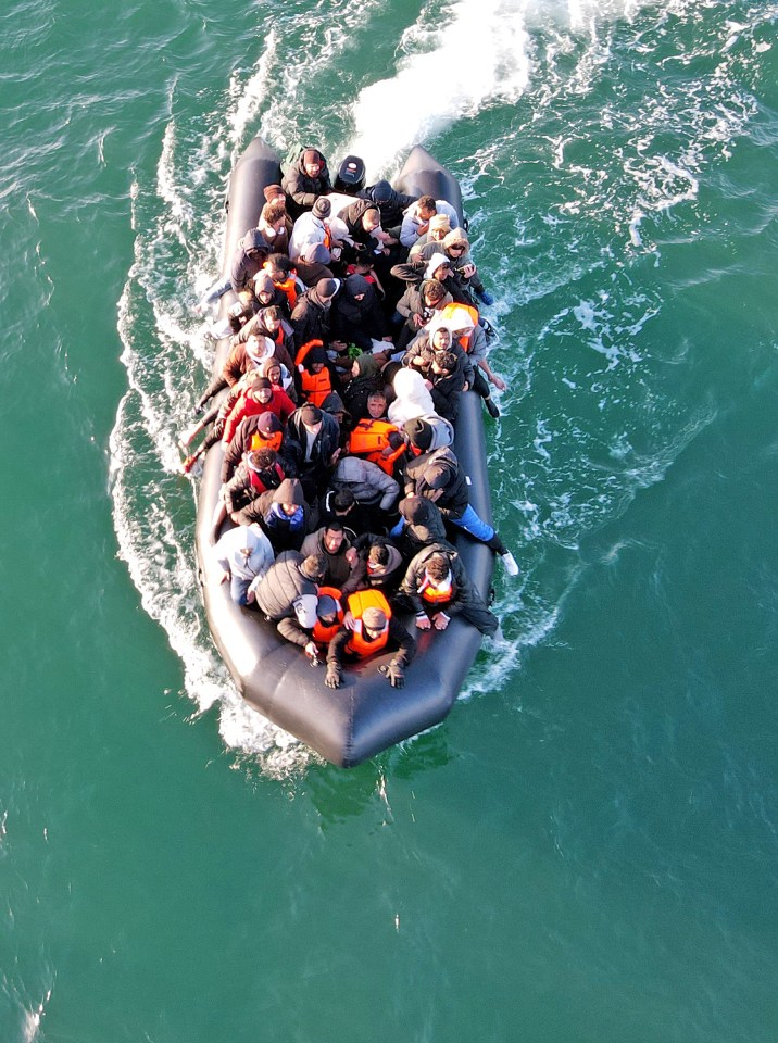 Overhead view of a crowded migrant dinghy in the English Channel.