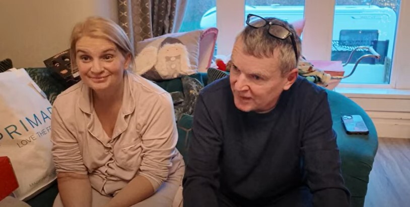 Sue and Noel Radford sitting on a couch.