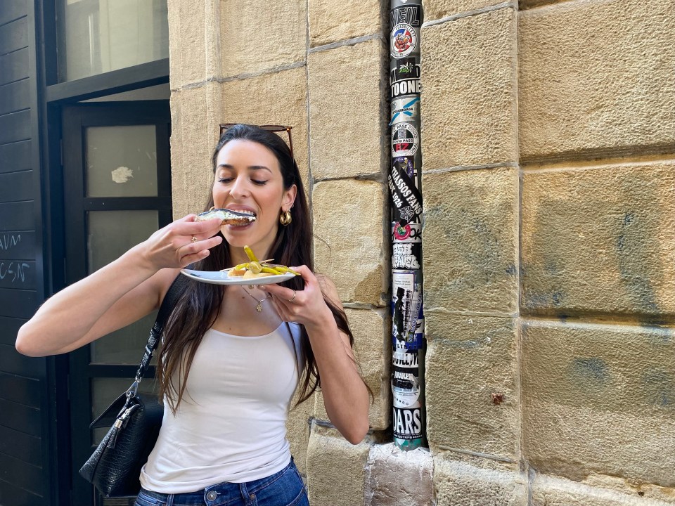 Woman eating tapas outdoors.