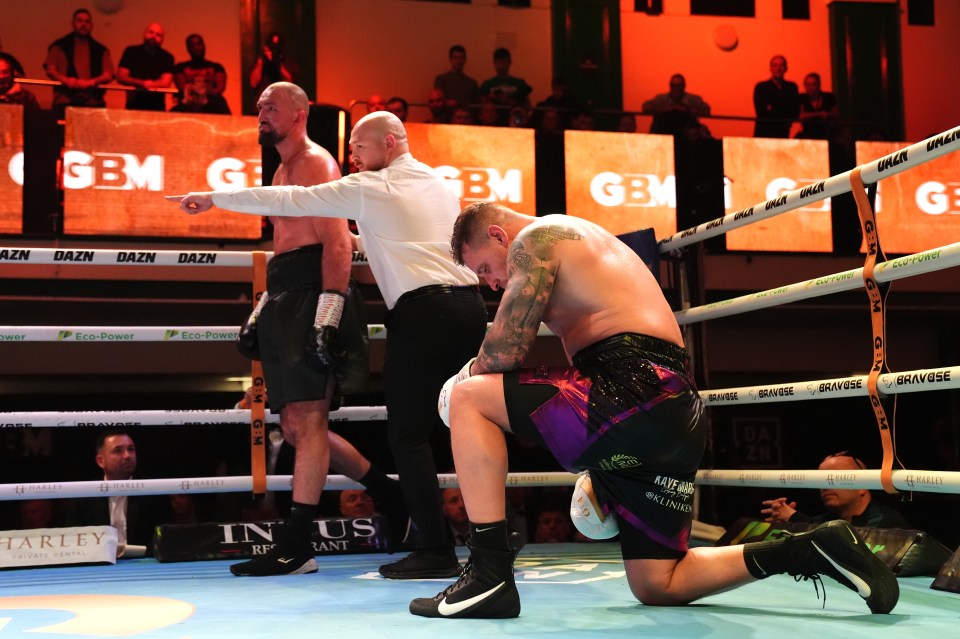 A boxer kneeling in the ring after a boxing match.