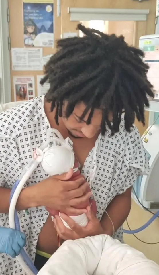 Two parents holding their newborn babies in a hospital.